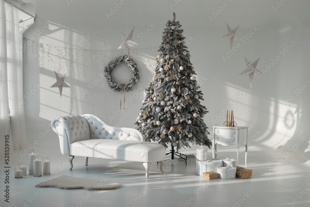 White room with sofa, Christmas tree, New year spruce and winter landscape in window. Scandinavian festive holidays design.