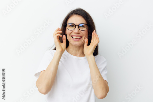 portrait of a nice, pleasant woman with a beautiful smile, in a white T-shirt and black glasses for vision.