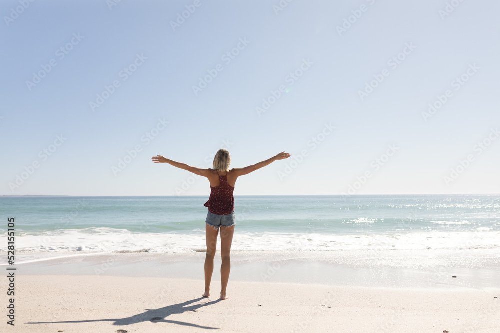 Young caucasian woman raising arms on the beach Young caucasian woman raising arms on the beach
