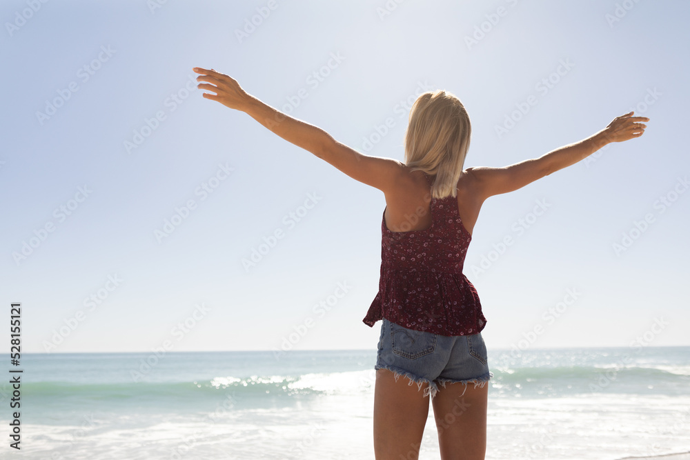 Young caucasian woman raising arms on the beach Young caucasian woman raising arms on the beach