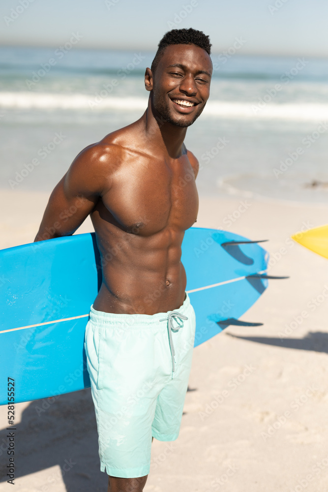 African American man holding a surfboard on the beach African American man holding a surfboard on the beach