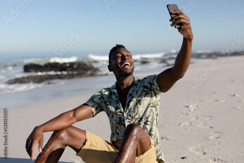 African american man taking a selfie on the beach