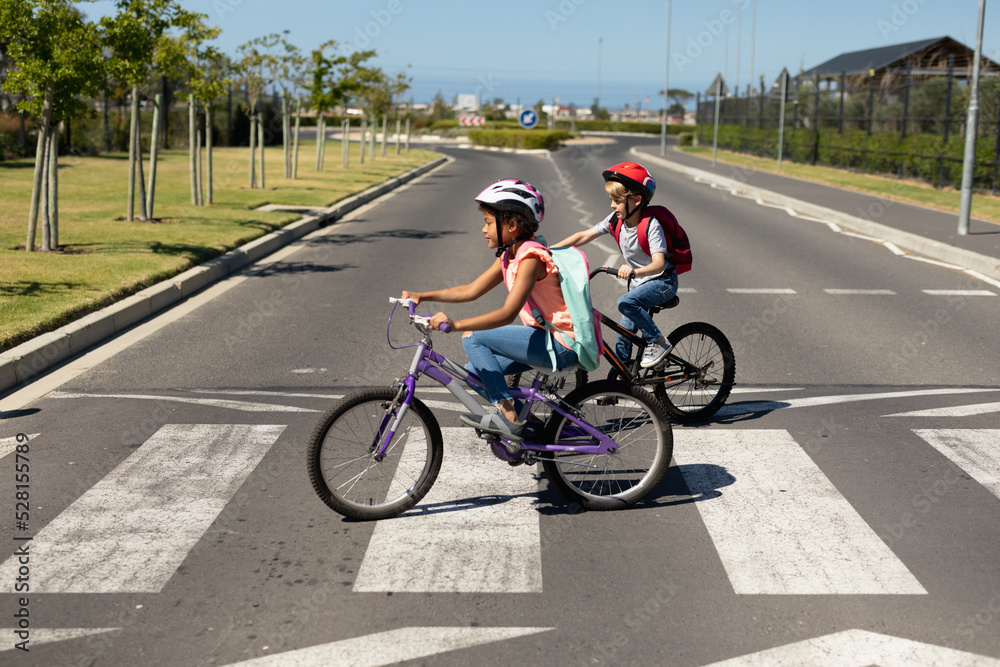 Obraz premium Schoolgirls crossing the road with bicycles
