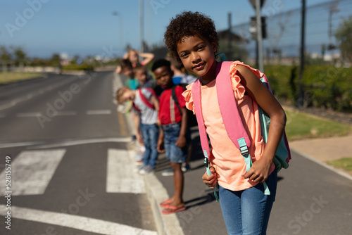 Schoolchildren looking for traffic while waiting to cross the road