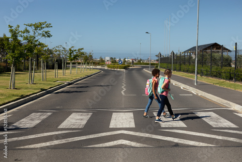 Schoolgirls crossing the road on a pedestrian crossing