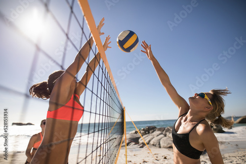 Female volleyball players playing on the beach