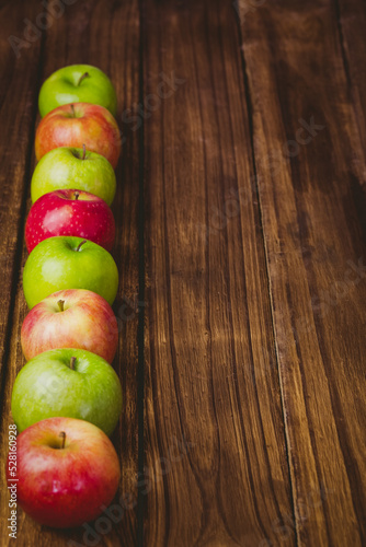 Red and green apples on table