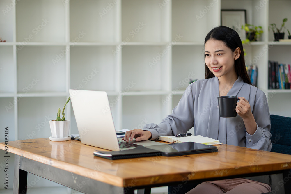Asian woman working in office with laptop and tablet online working concept Asian woman working in office with laptop and tablet online working concept