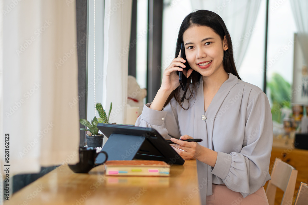 Asian woman in casual wear working on tablet and smartphone, online learning and education concept Asian woman in casual wear working on tablet and smartphone, online learning and education concept
