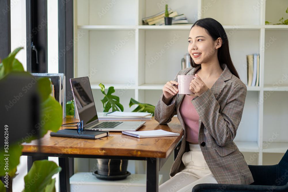 Asian woman working in office with laptop and tablet online working concept Asian woman working in office with laptop and tablet online working concept