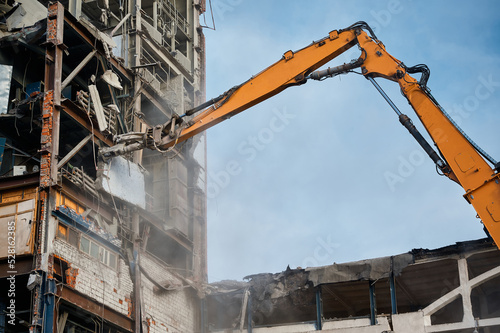 Hydraulic scissors on rig of crane cut building on site