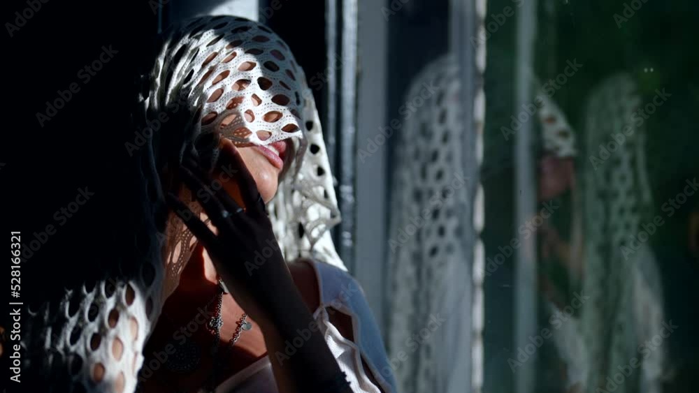 attractive sensual woman is looking at window, white lace scarf on her face and head, portrait attractive sensual woman is looking at window, white lace scarf on her face and head, portrait
