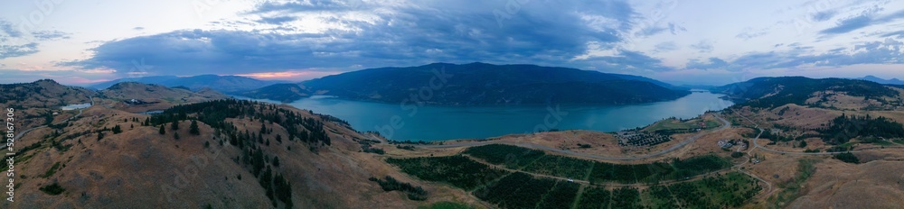 Aerial View of Canadian Landscape with Kalamalka Lake and Mountains. Colorful Cloudy Summer Sunrise. Near Vernon, Okanagan, BC, Canada. Nature Background Panorama