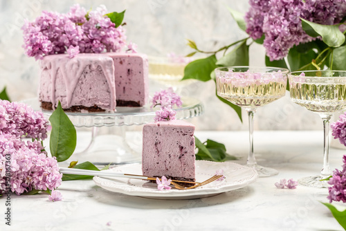 Delicious berry mousse cake, with prosecco, champagne, wine, bouquet of purple blooming lilacs, French cuisine, postcard, background