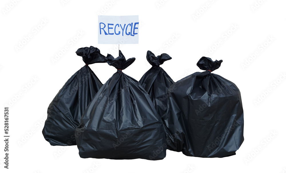 Pile of black plastic bags that contain garbage inside. Paper sign with word 