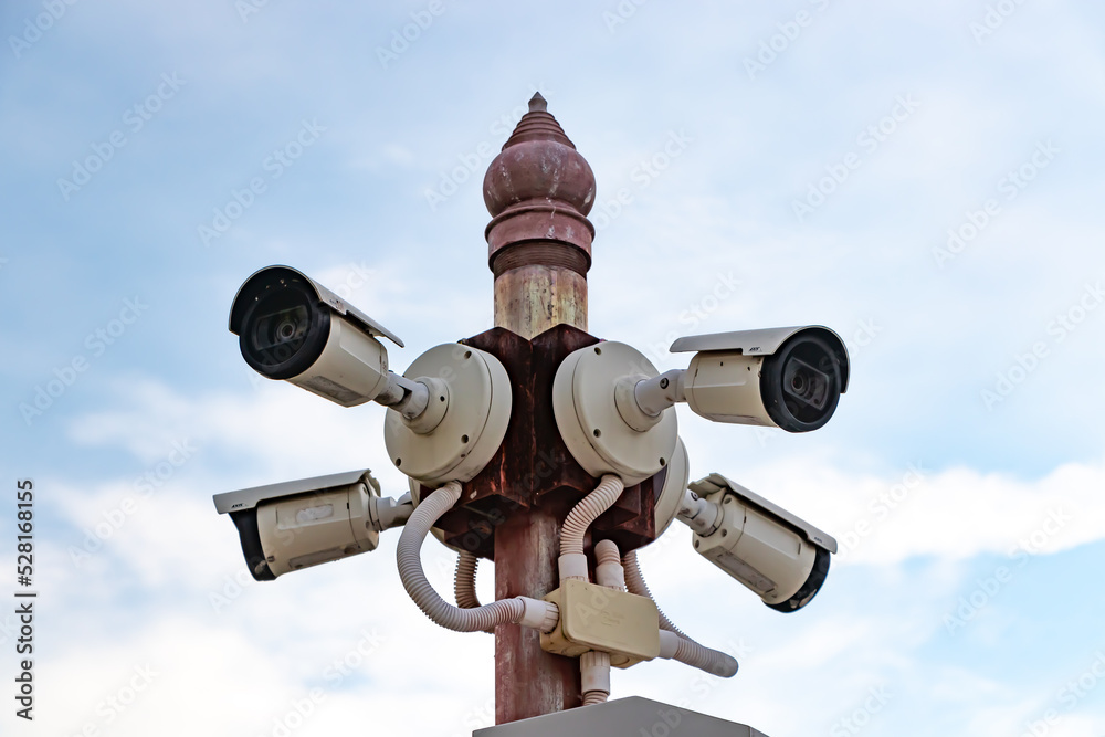 Multiple CCTV cameras mounted on poles, many CCTV cameras with blue sky in the morning