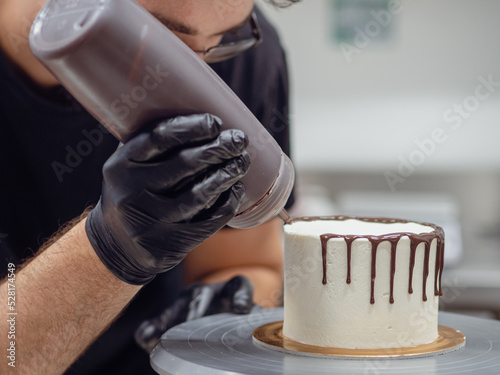 cake designer drip glazing with chocolate ganache a creamy white smooth cake photo