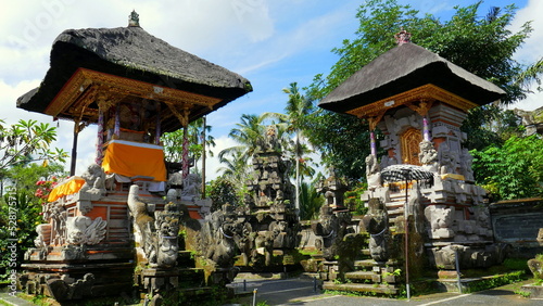 kleine hinduistische Tempelschreine mit schönen Steinskulpturen vor tropischen Bäumen in Bali