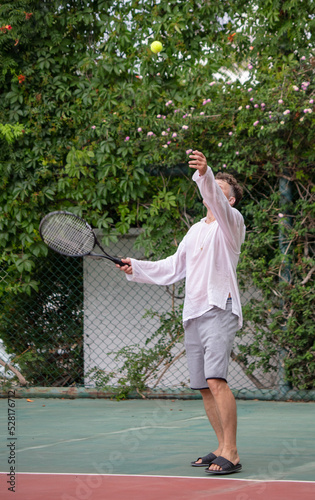 A man plays tennis on the court. © schankz