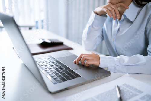 Asian Woman working by using a laptop computer  Hands typing on keyboard. Working at office professional investor working new start up