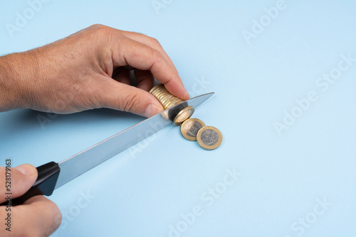 the gesture of cutting Euro coins with the knife. concept of installment payment of debt.