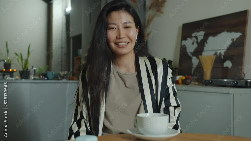 Portrait of cheerful student chatting and waving hand enjoying online video call at home in kitchen. Virtual meeting and positive emotion concept. Portrait of cheerful student chatting and waving hand enjoying online video call at home in kitchen. Virtual meeting and positive emotion concept.