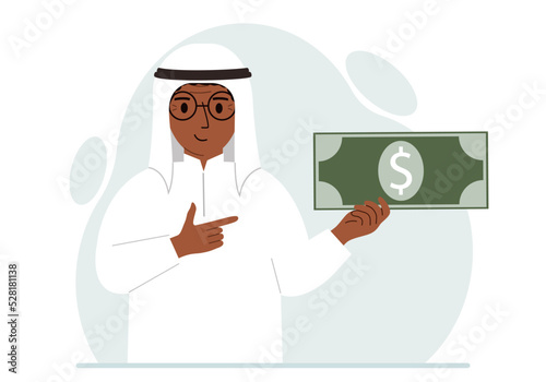 A arab man holds a large paper bill in his hand. The concept of income, expense, earning or spending money.