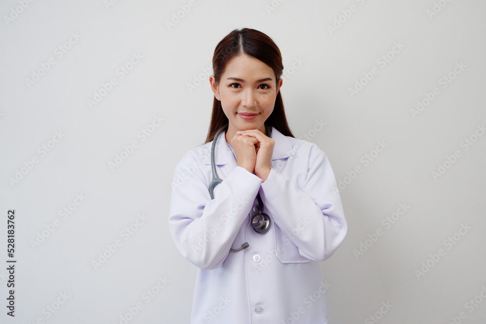 Beautiful Asian female doctor standing smiling happy to show pride or success with a stethoscope on the shoulder wearing a white medical gown. Beautiful Asian female doctor standing smiling happy to show pride or success with a stethoscope on the shoulder wearing a white medical gown.