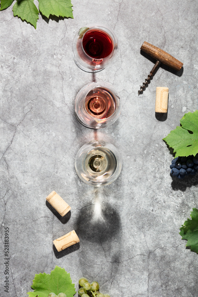 Wine composition with beautiful sunlight and shadows on grey background. Top view, flat lay