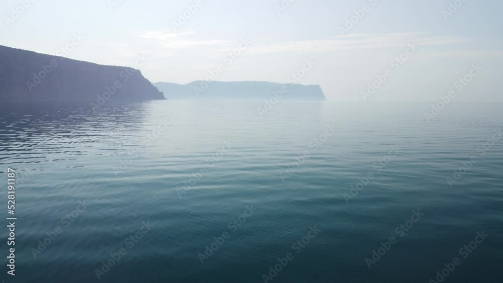 Aerial view from above on calm azure sea and volcanic rocky shores. Small waves on water surface in motion blur. Nature summer ocean sea beach background. Nobody. Holiday, vacation and travel concept Aerial view from above on calm azure sea and volcanic rocky shores. Small waves on water surface in motion blur. Nature summer ocean sea beach background. Nobody. Holiday, vacation and travel concept