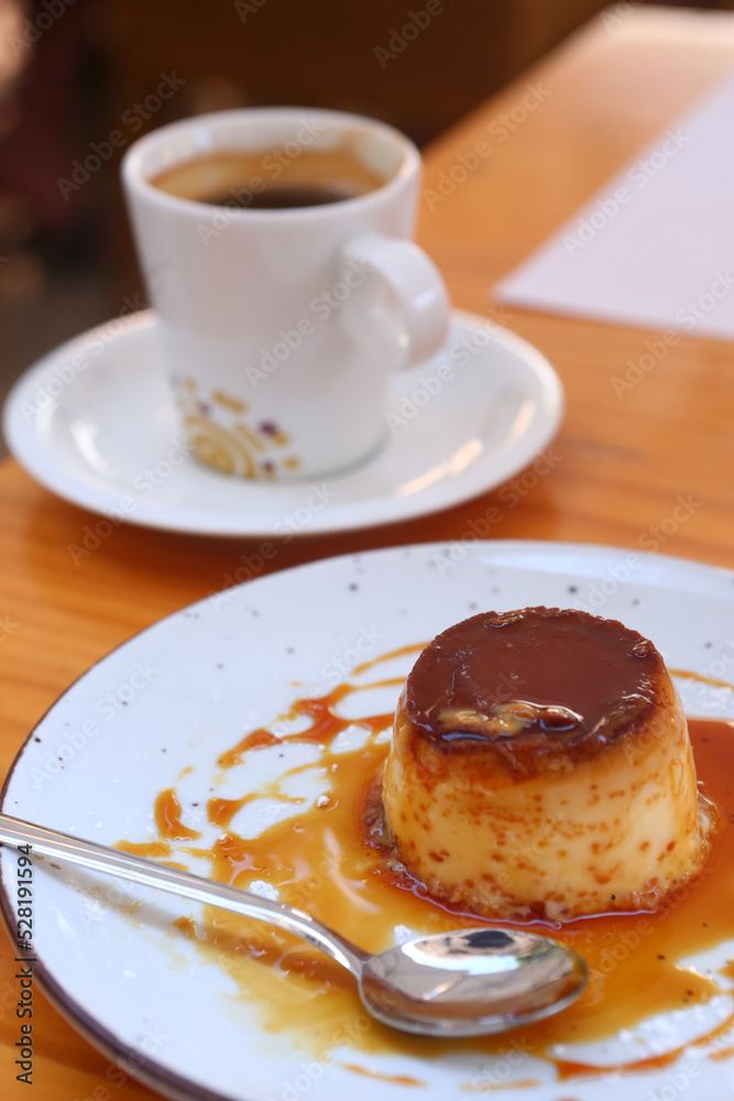 spanish flun pudding dessert closeup photo with teaspoon and cup of coffee on the background spanish flun pudding dessert closeup photo with teaspoon and cup of coffee on the background