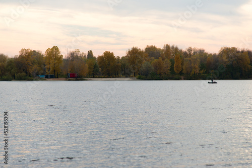 beautiful landscape with a river, a silhouette of a man on a boat.