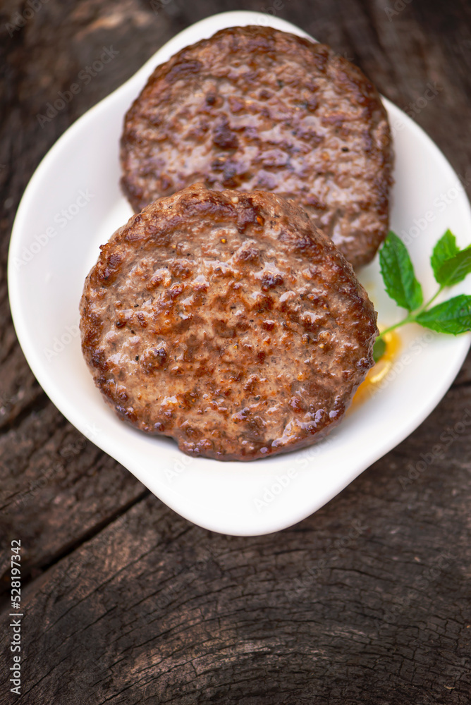 appetizing beef cutlet for burger on wooden background
