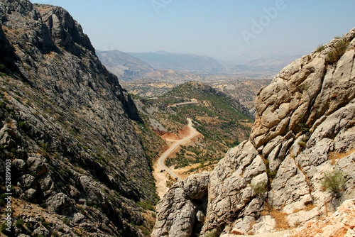 Landscape with mountains, plains and a road between them near Nemrut Dag mountain, in Southeastern Anatolia region, Turkey photo