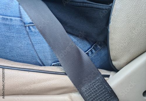 Male driver sits in car with seat belt fastened for safety closeup
