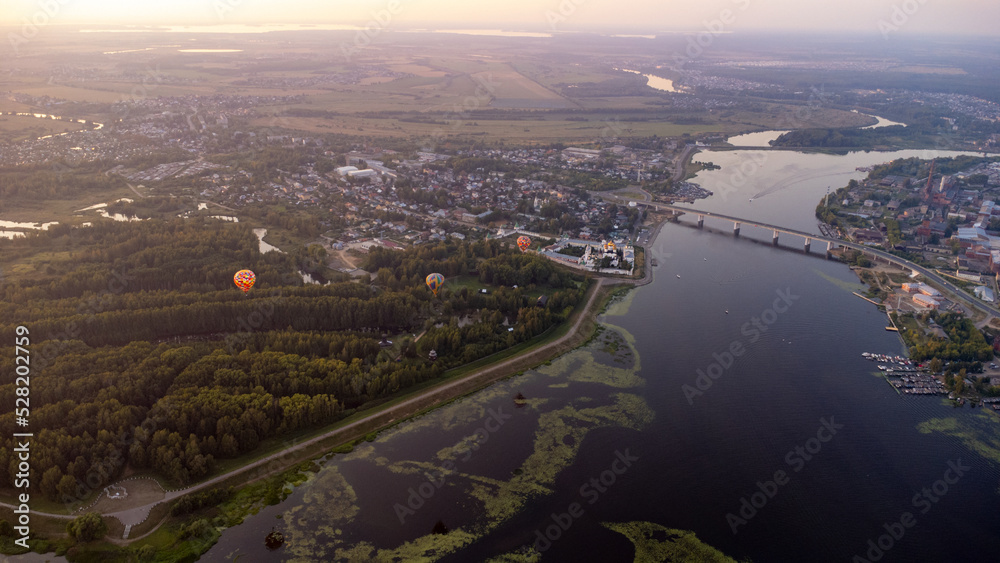 Drone aerial view of hot air balloons over the Volga river in the Kostroma region at sunset. travel background Drone aerial view of hot air balloons over the Volga river in the Kostroma region at sunset. travel background