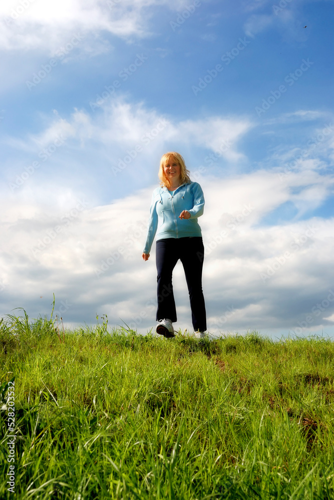 happy blonde woman in her forties outdoor in nature