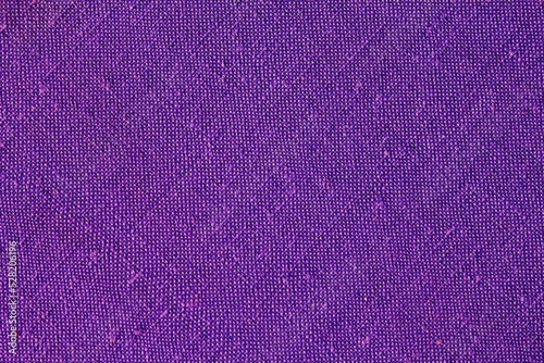 Abstract design background of violet coarse-grained intersection texture of rough fabric with an interlacing. Linen sack textile canvas burlap cloth. Witch hat halloween color. Close up, top view