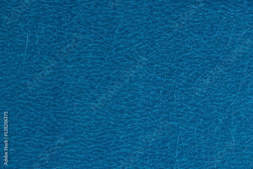 Abstract design background of glossy artificial genuine textured deep blue creased leather. Flat surface. Skin natural wrinkled scratched wallpaper winter sale pattern. Close-up, mock up, top view
