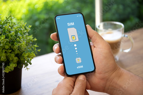man hands holding phone with Sim card replacement on eSim