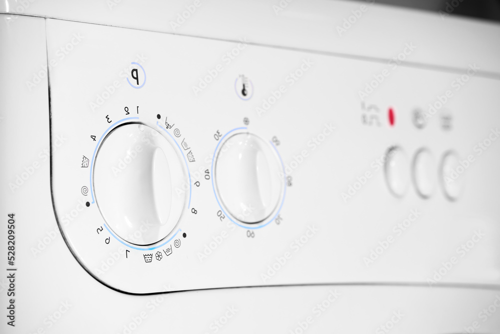 Close up of temperature control and program knobs on white washing machine Close up of temperature control and program knobs on white washing machine