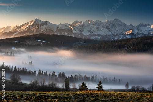 View of the Tatra Mountains, meadows, pastures, fogg, from Gliczarów Górny. Spring, Poland. Widok na Tatry, góry, łąki, hale, z Gliczarowa Górnego. Mgła, wiosna, Podhale, Polska. Krajobraz, poranek