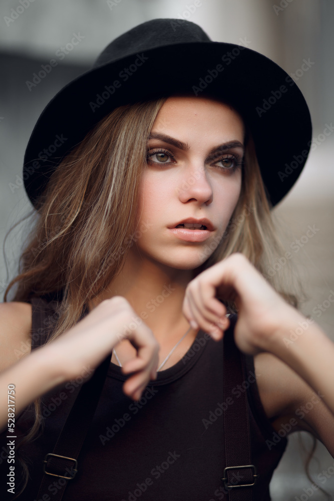 Beautiful attractive stylish woman in a hat on the background of the street. summer fashion style trend Beautiful attractive stylish woman in a hat on the background of the street. summer fashion style trend