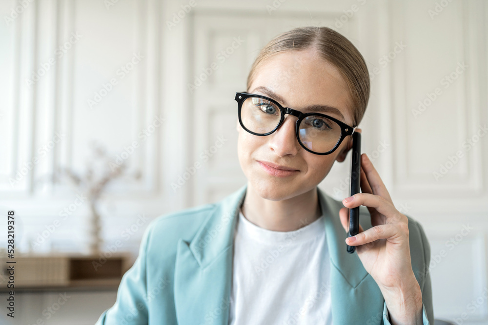 Portrait of a close woman with glasses using a phone talking to a client Portrait of a close woman with glasses using a phone talking to a client