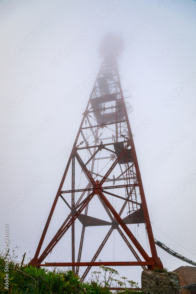 Radio repeater on top of a mountain in dense fog. Russia Ossetia