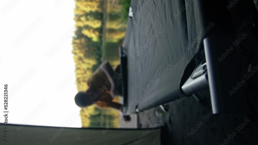 custom made wallpaper toronto digitalMan installing bed inside a tent outdoors and rolling out mat. vertical video