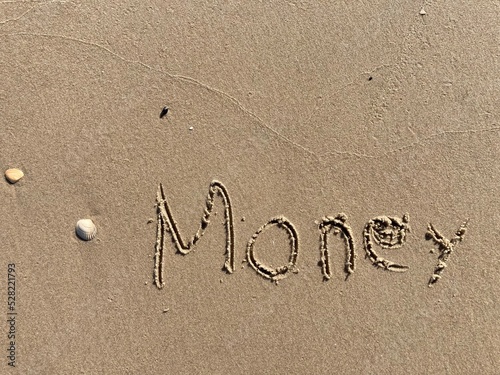 on the beach is carved with letters in the smooth sand the writing Money © Marcus