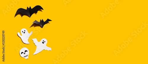 Halloween set decorations with ghost  bat and skeleton on yellow background. Holiday party  minimal card  spooky concept. flat lay  copy space  top view  place for text