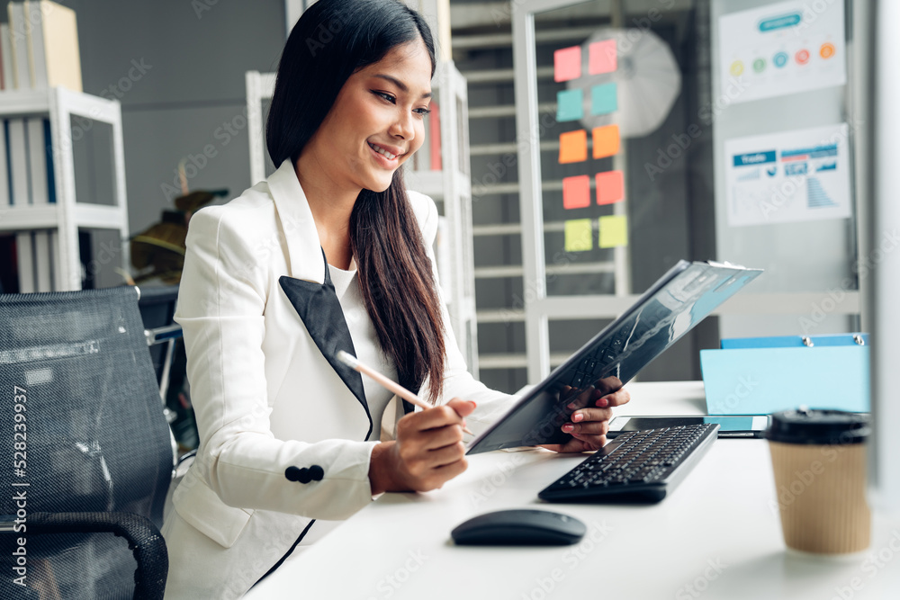 Successful businesswoman working at her office desk, Concept of business risk analysis and assessment Successful businesswoman working at her office desk, Concept of business risk analysis and assessment