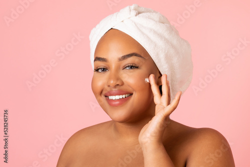 Obese African American Female Applying Cream Moisturizing Face, Pink Background